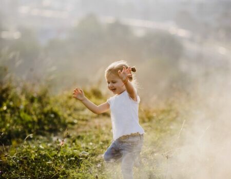 beautiful-little-girl-white-shirt-jeans-runs-lawn-fog-with-great-landscape_8353-7528